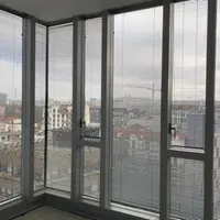 Stores-venitiens-aluminium-hautes-fenetres-dans-un-bureau.webp
